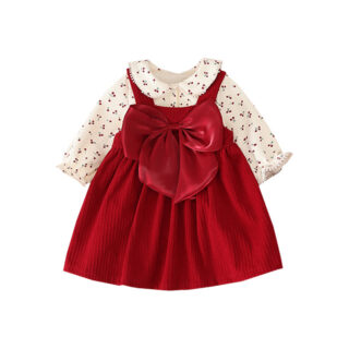 On voit un ensemble pour bébé fille qui comprend une robe à bretelles en velours côtelé et un chemisier à col claudine imprimé à motif cerise. L'ensemble est très élégant et formel, idéal pour une fête de famille.