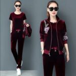 Deux femmes portant des vêtements rouges bordeaux et des lunettes de soleil.