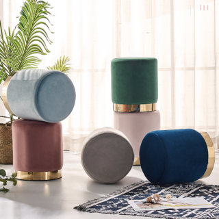 Phoot de plusieurs pouf en velours avec une base dorée dans un salon moderne