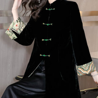 Veste Kimono en velours noir avec attaches vertes et manches motif fleuri japonisant porté par une femme assise avec un pantalon en simili cuir noir