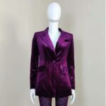 blazer violet en velours sur un mannequin en plastique blanc, sur fond gris