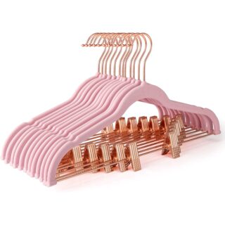une dizaine de cintres en velours roses à clips et crochet dorés, sur fond blanc