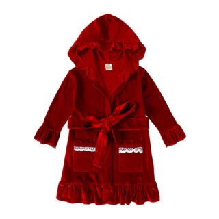 On voit un peignoir en velours rouge sur fond blanc. Il est dans le thème de Noël et conçu pour les bébés.