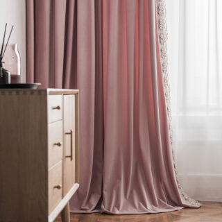 On voit un rideau rose en velours dans une chambre